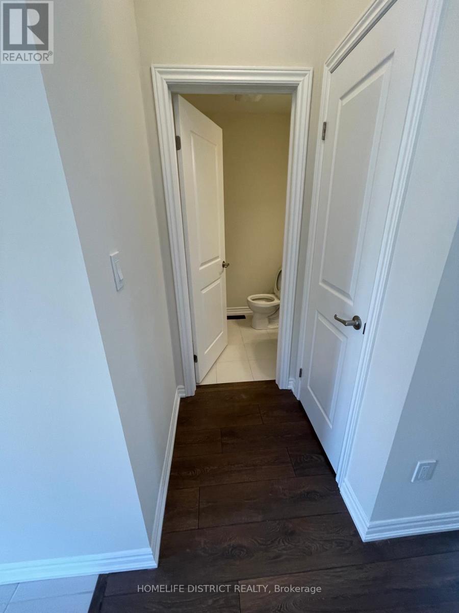 A hallway with white walls and wood floors.