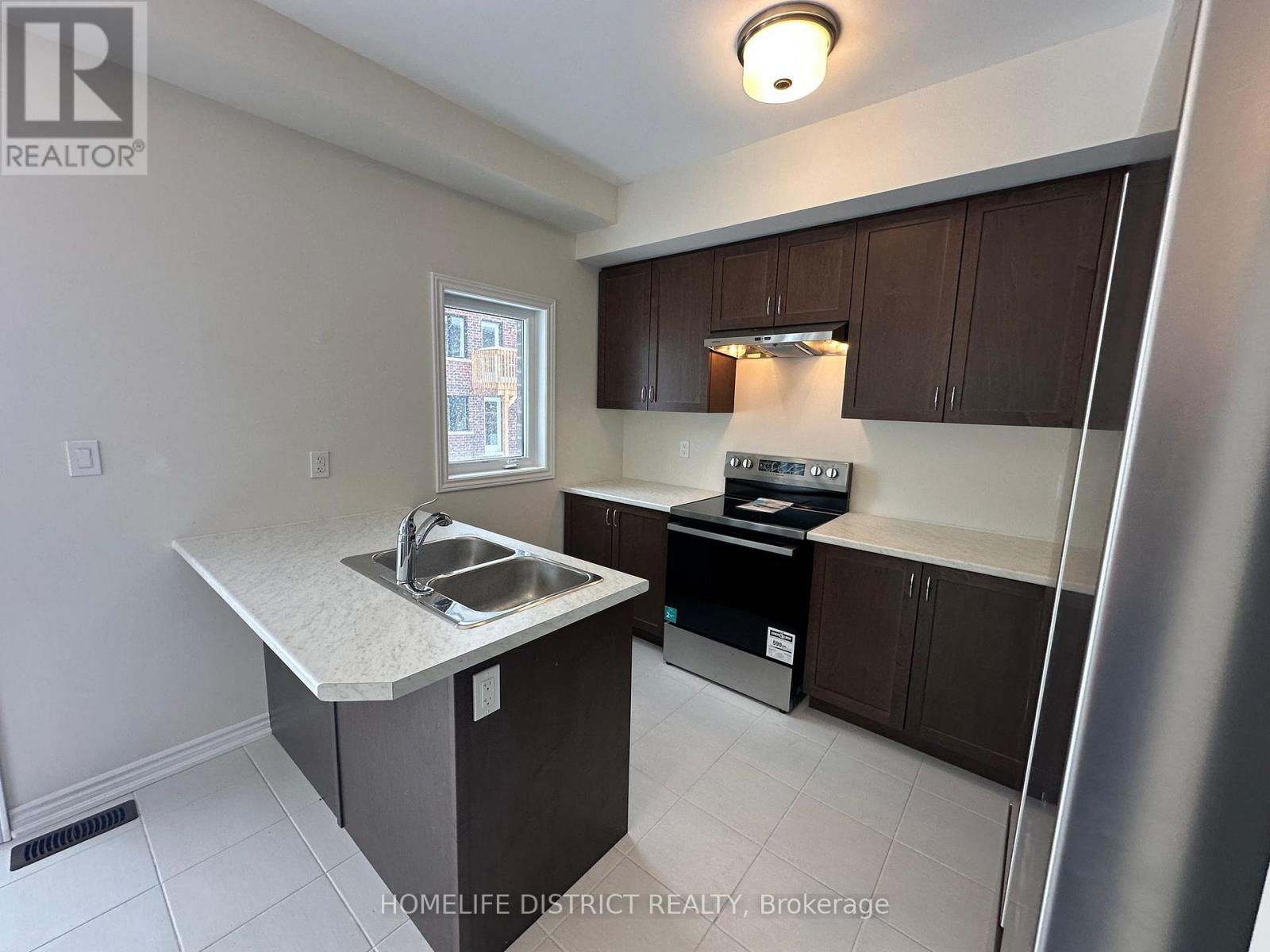 A kitchen with a sink and a refrigerator.