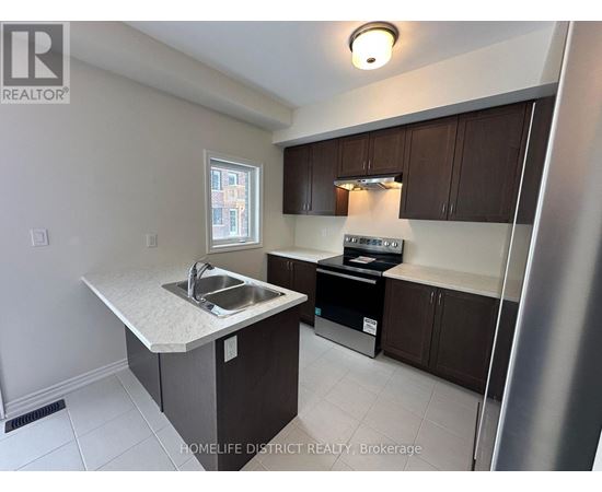 A kitchen with a sink and a refrigerator.