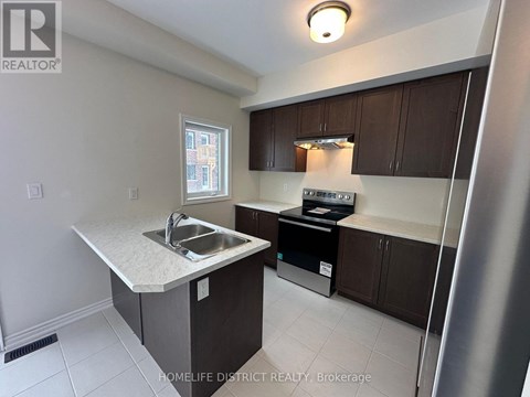 A kitchen with a sink and a refrigerator.