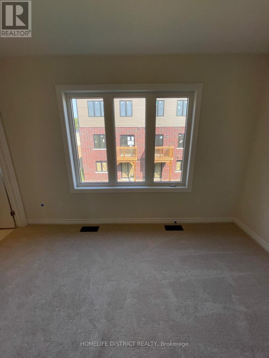 A room with a large window overlooking a red brick building.