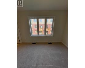 A room with a large window overlooking a red brick building.