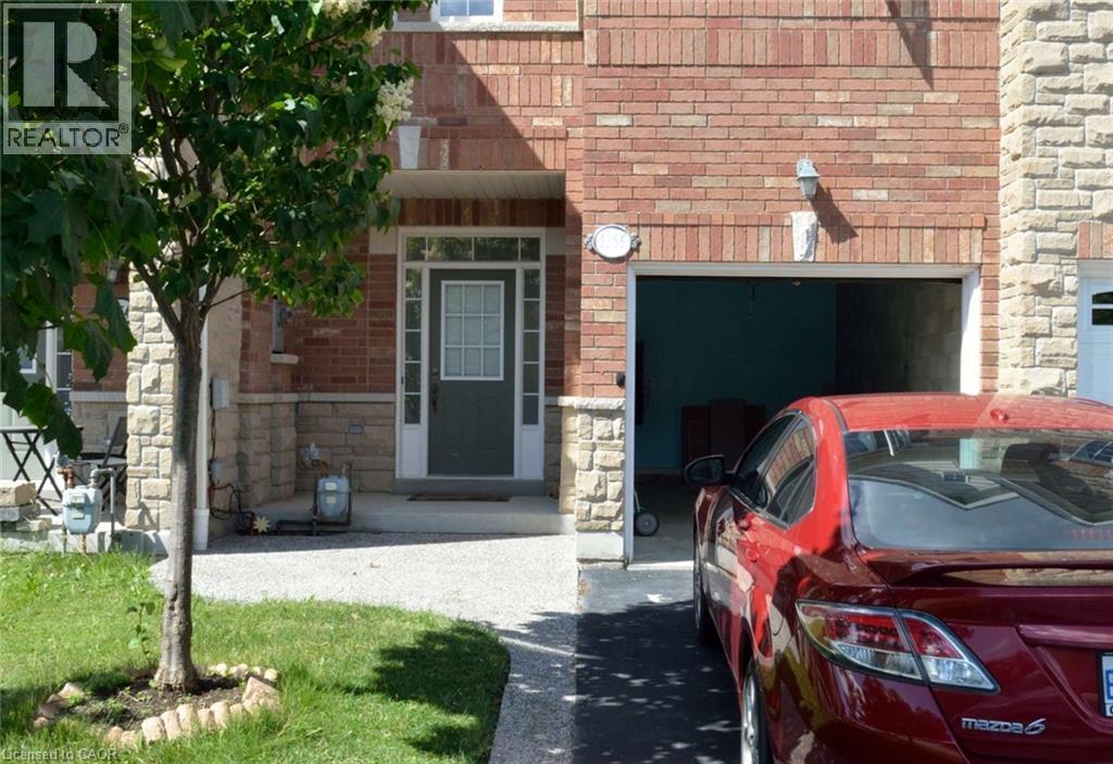 A red car is parked in front of a garage.