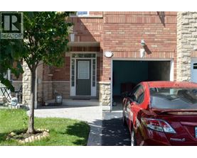 A red car is parked in front of a garage.
