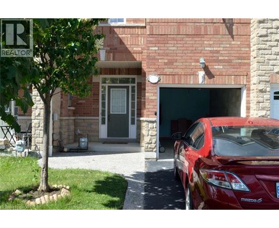 A red car is parked in front of a garage.