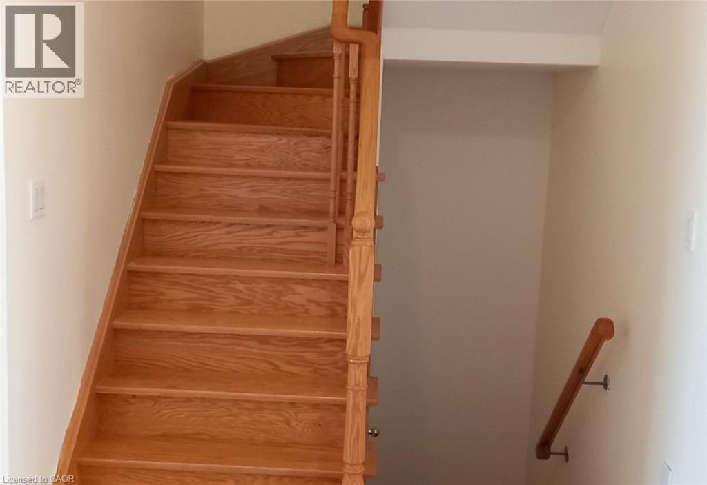 A wooden staircase with a white wall on the side.