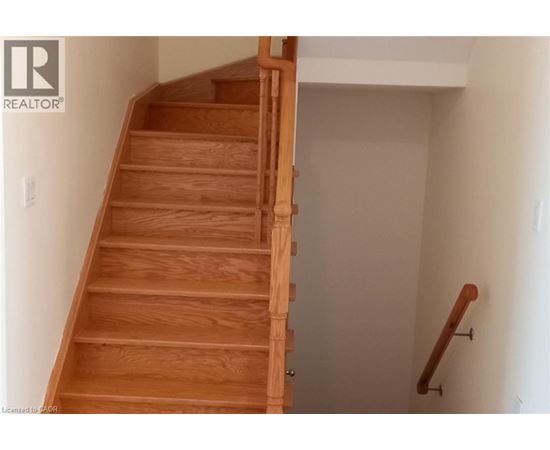 A wooden staircase with a white wall on the side.