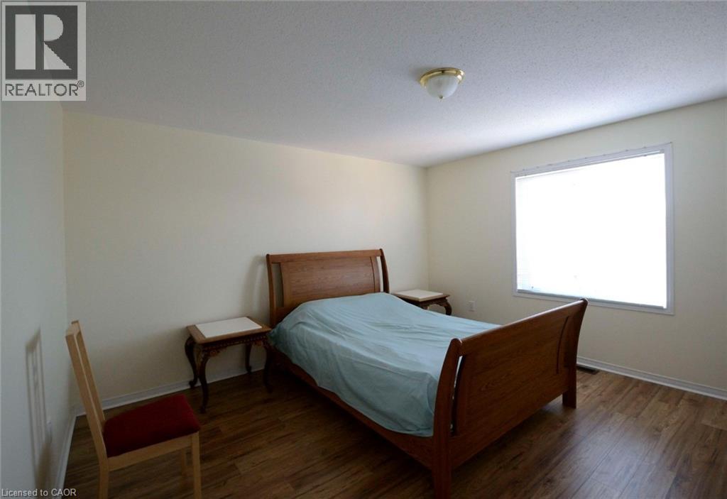 A bedroom with a bed, chair, and window.