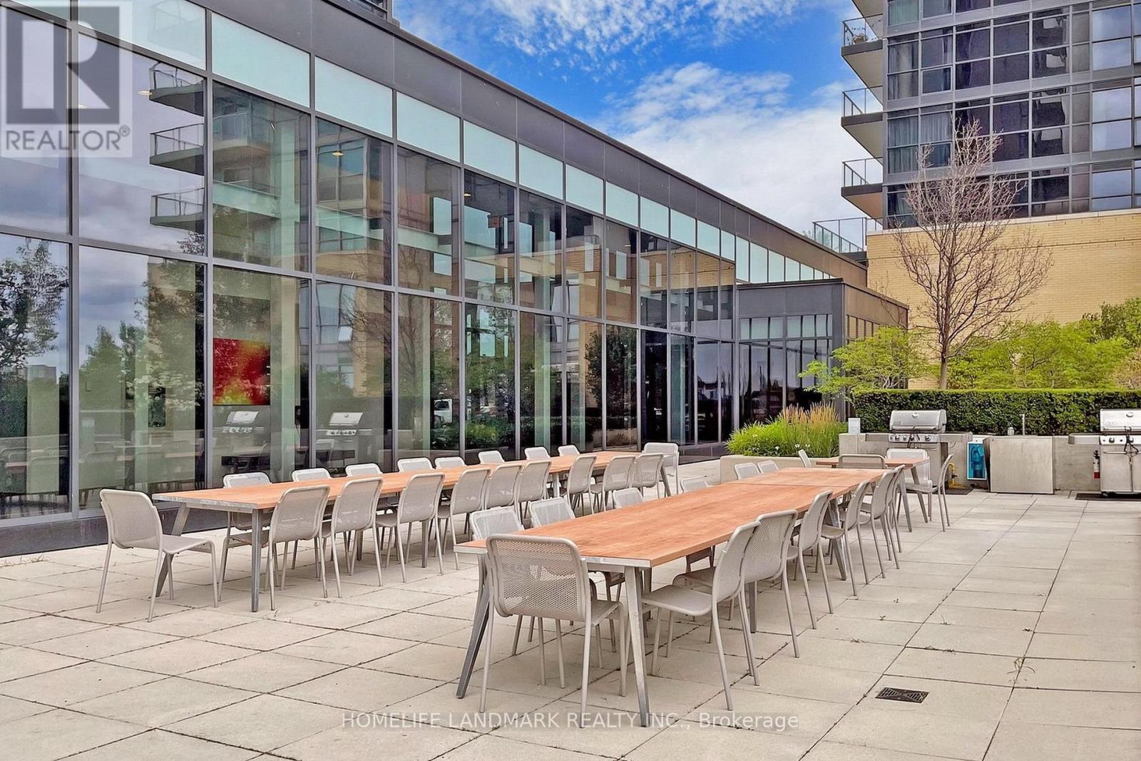 A glass building with a table and chairs outside.