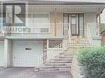 A house with a white garage door and a porch with a railing.