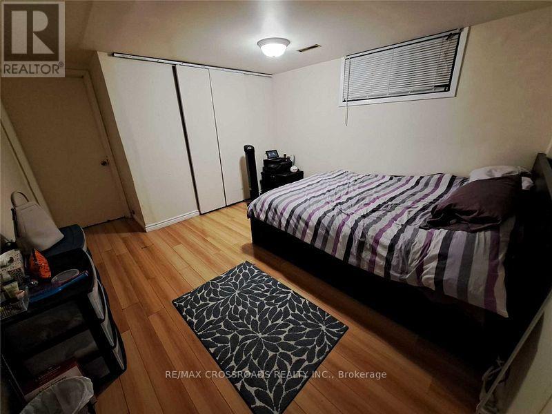 A bedroom with a bed, a nightstand, and a rug.