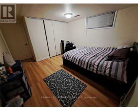 A bedroom with a bed, a nightstand, and a rug.