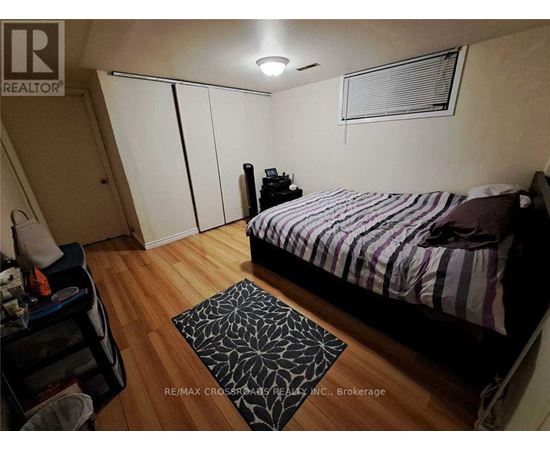A bedroom with a bed, a nightstand, and a rug.