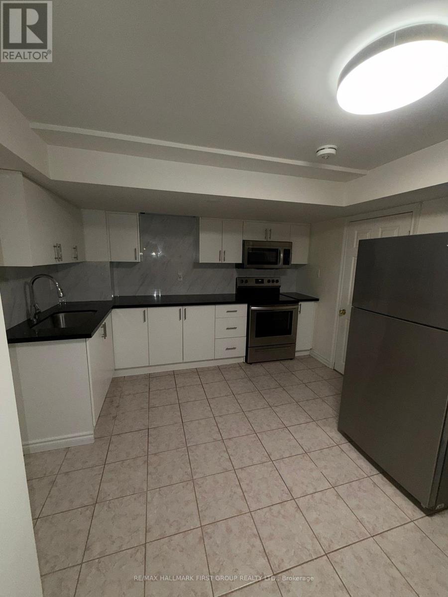 A kitchen with white cabinets and a black countertop.