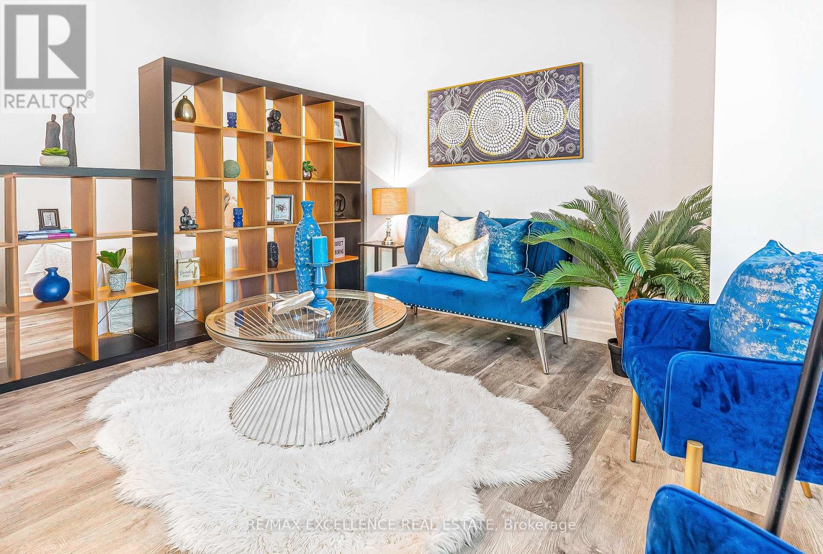 A living room with a glass table and blue couches.