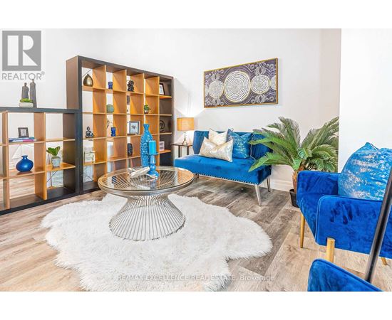A living room with a glass table and blue couches.