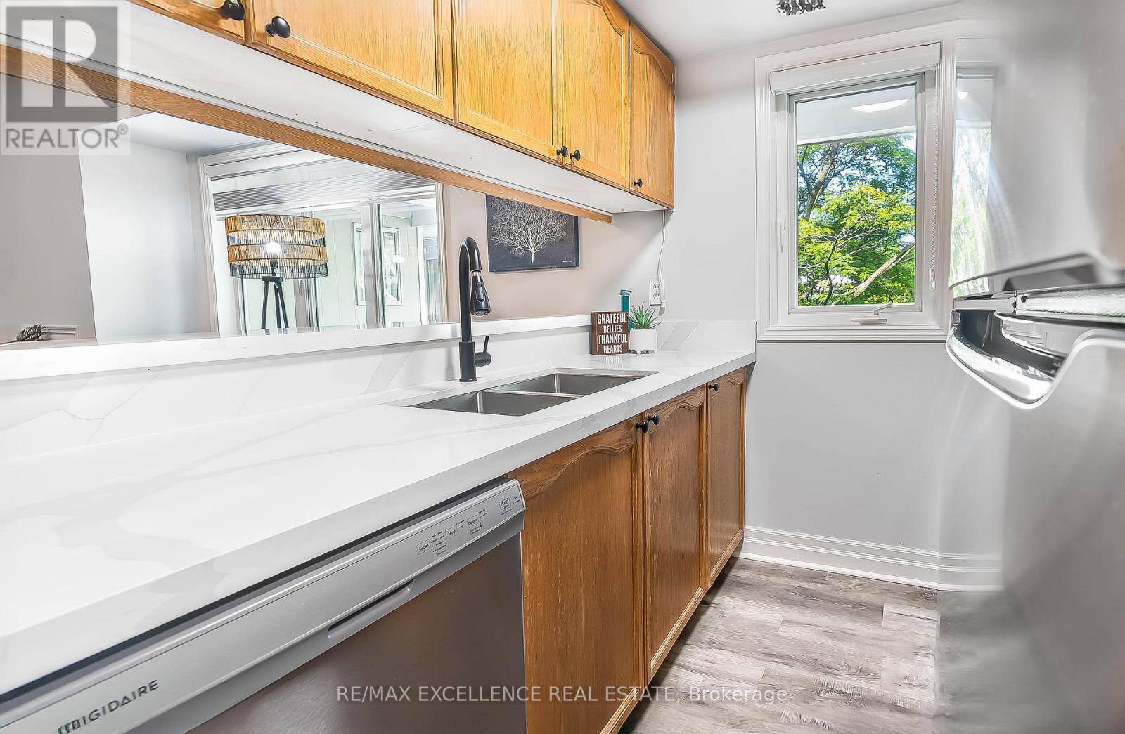 A kitchen with wooden cabinets and a stainless steel dishwasher.