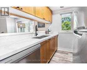 A kitchen with wooden cabinets and a stainless steel dishwasher.
