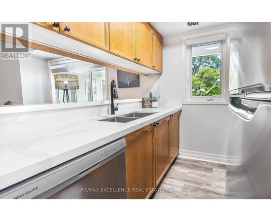 A kitchen with wooden cabinets and a stainless steel dishwasher.