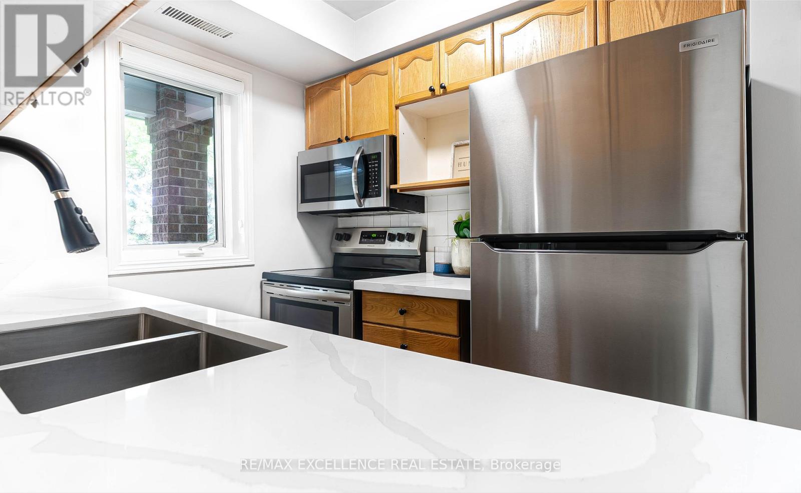 A modern kitchen with a stainless steel refrigerator and wooden cabinets.