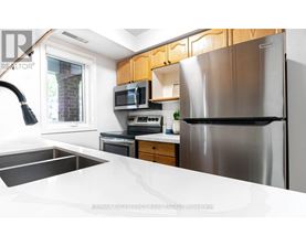 A modern kitchen with a stainless steel refrigerator and wooden cabinets.