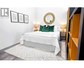 A bedroom with a white bed and a mirror above it.