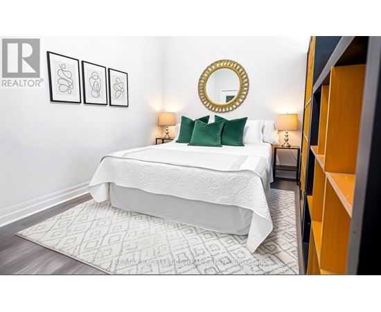 A bedroom with a white bed and a mirror above it.
