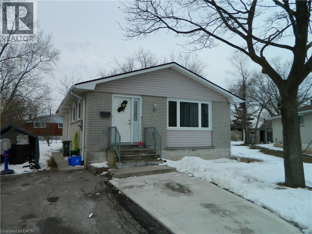 A house with a grey roof and a white door is surrounded by snow.