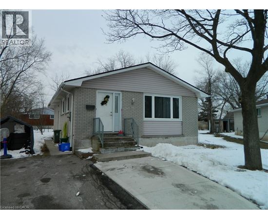 A house with a grey roof and a white door is surrounded by snow.