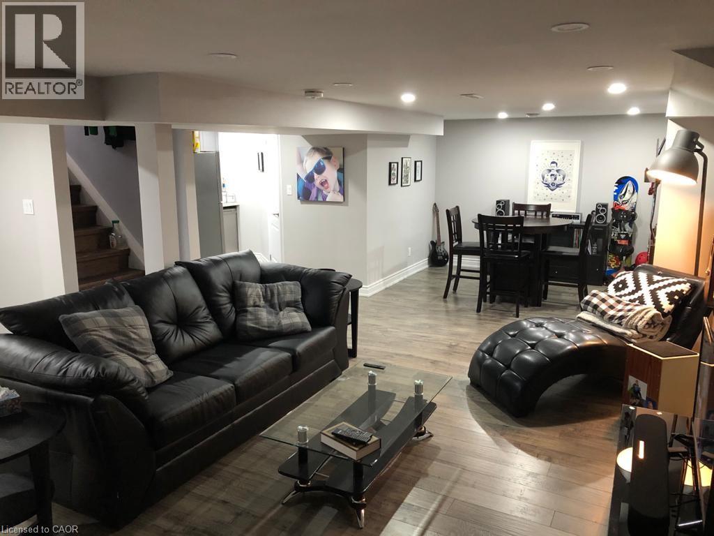 A living room with a black leather couch and a coffee table.