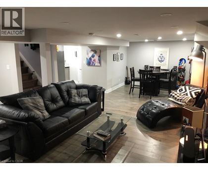 A living room with a black leather couch and a coffee table.
