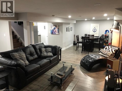 A living room with a black leather couch and a coffee table.