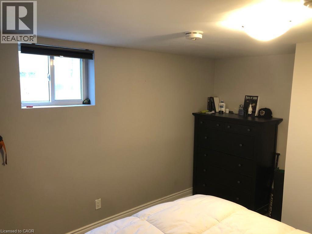 A bedroom with a bed, dresser, and window.