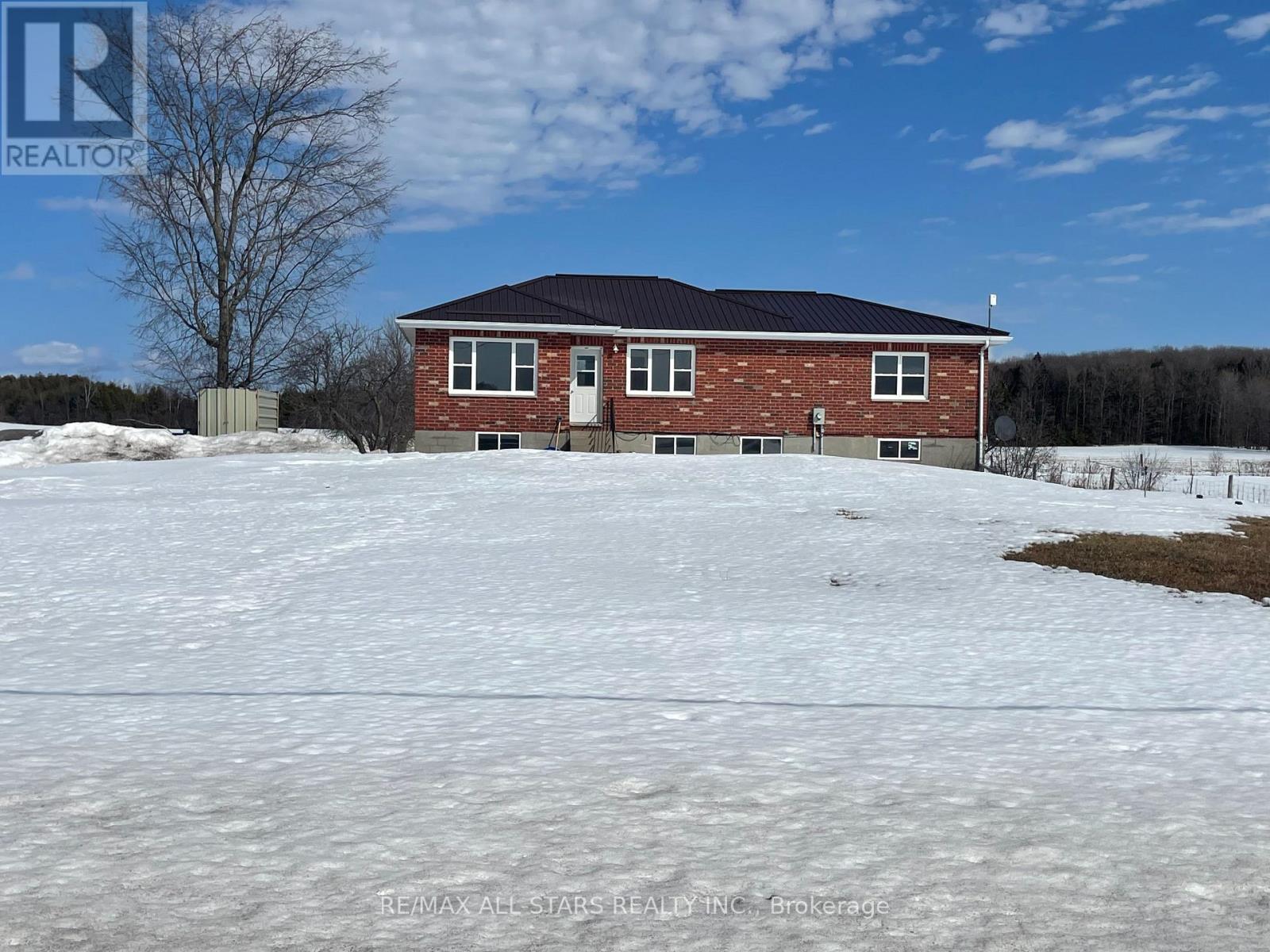 A house with a snowy yard in front of it.