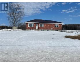 A house with a snowy yard in front of it.