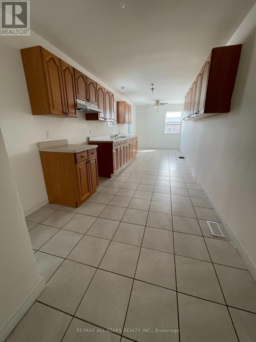 A kitchen with white tiled floors and wooden cabinets.