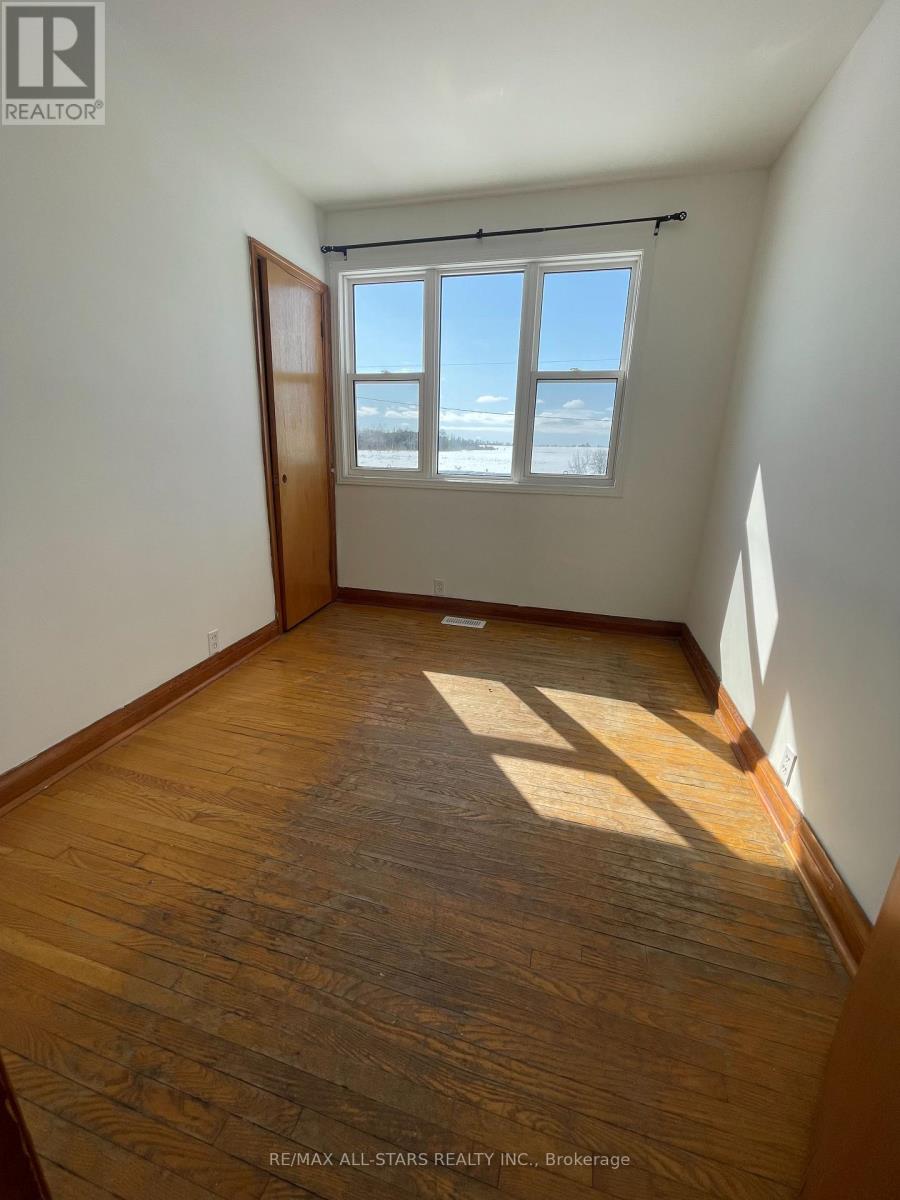 A room with wooden floors and a window with blinds.