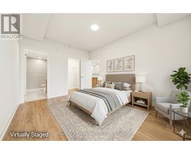 A bedroom with a bed, nightstand, and chair.