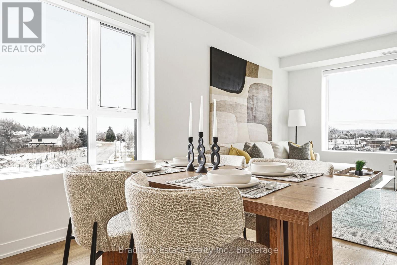A dining room with a table set for two and a view of a snowy landscape outside the window.