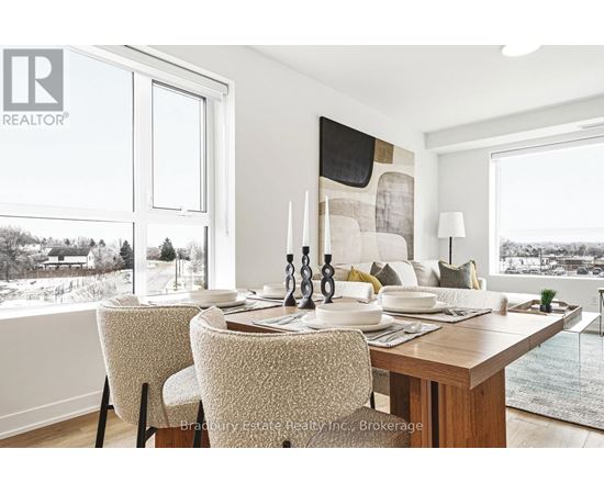 A dining room with a table set for two and a view of a snowy landscape outside the window.