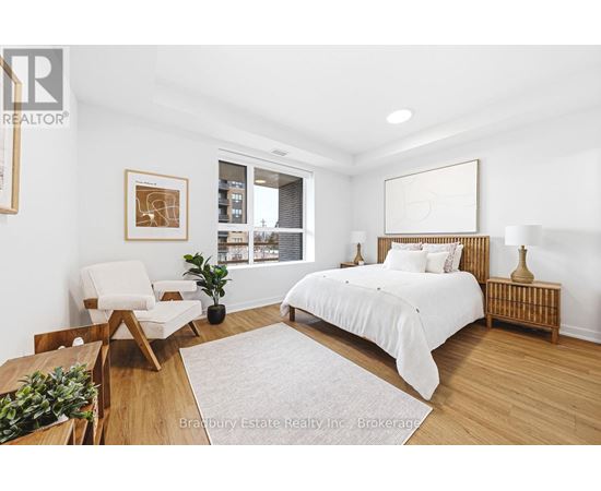 A bedroom with a bed, chair, and a potted plant.