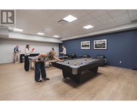 A woman is playing pool in a room with a pool table and a few other people.