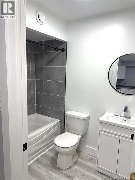 A white toilet sits next to a white sink in a bathroom.