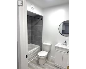 A white toilet sits next to a white sink in a bathroom.