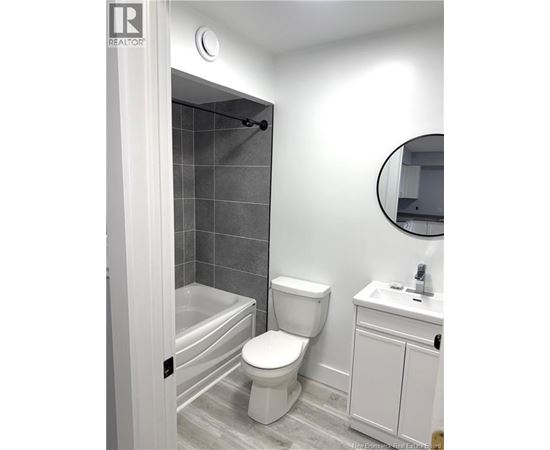 A white toilet sits next to a white sink in a bathroom.