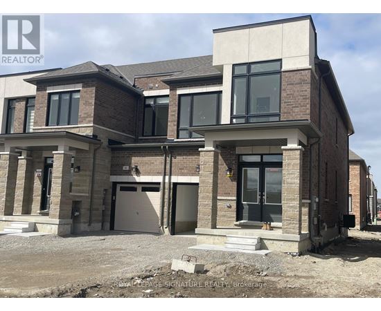 A modern house with a brick facade and large windows is under construction.