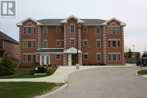 A large brick building with a white entrance and a sign that says "ED Lowe LIMITED, Brokerage".