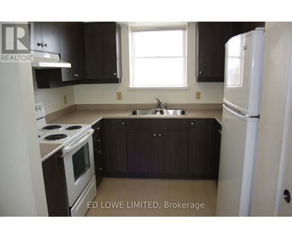 A kitchen with a stove, sink, and refrigerator.