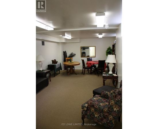 A living room with a couch, chair, and lamp.