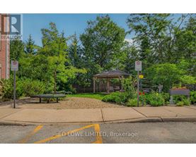 A park with a gazebo, bench, and trees.